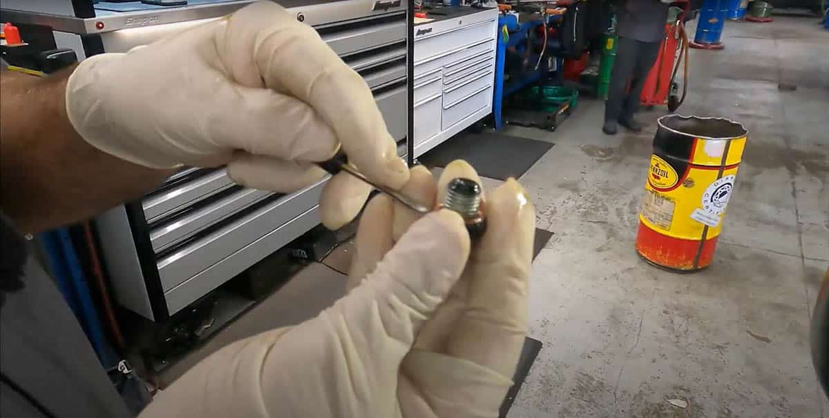 Tommy removing copper washer from drain plug