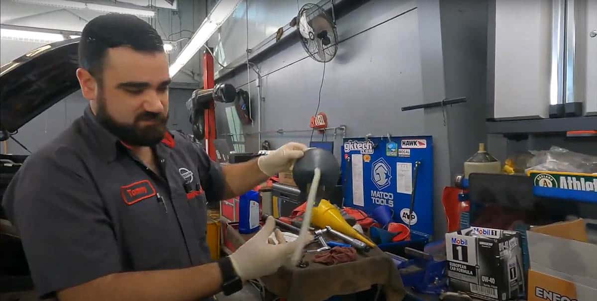 Tommy demonstrating one of the funnel types used for Nissan CVT fluid changes