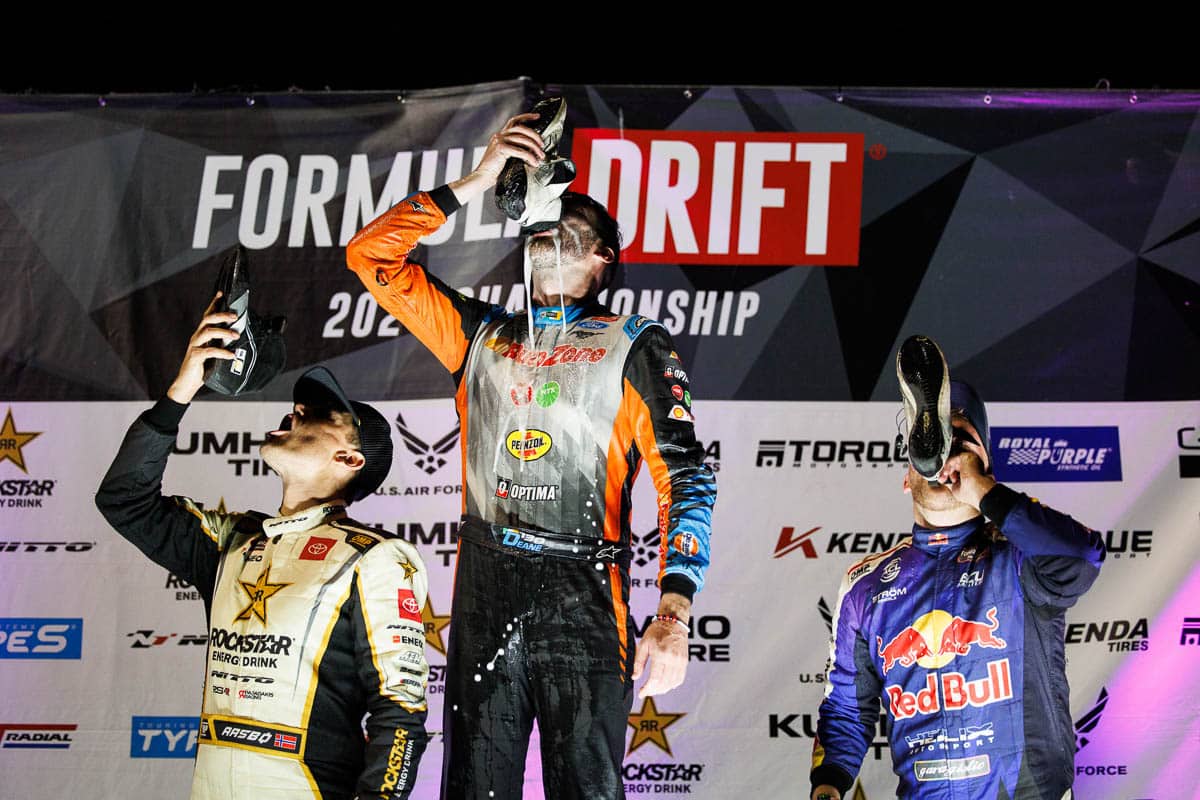 Aasbo enjoys a “shoey” with James Deane and Conor Shanahan at the Irwindale podium, 2024 Formula DRIFT Irwindale